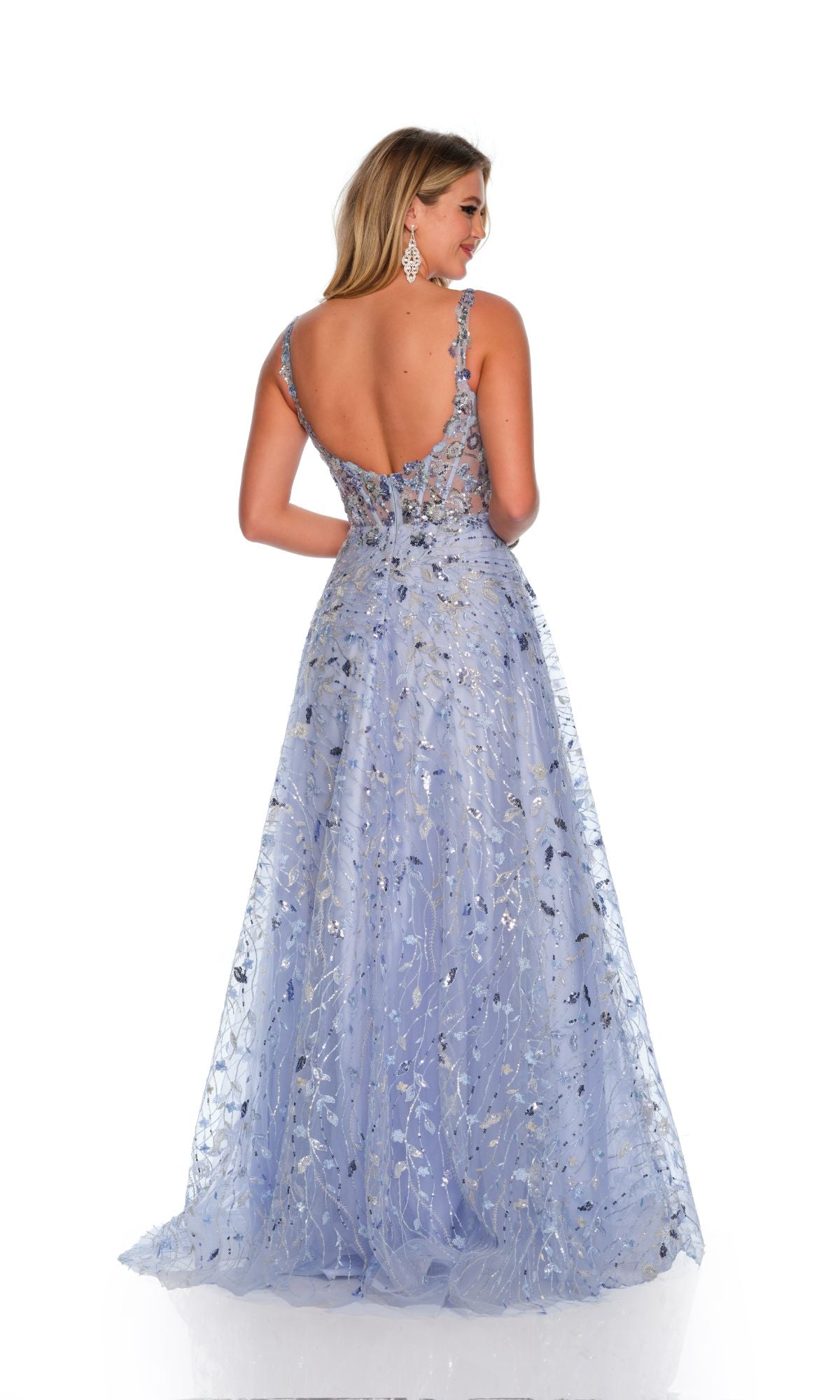 A woman faces away from the camera wearing the Long Formal Dress 11502 by Dave and Johnny—a lavender A-line ball gown with silver sequin details and an open back, set against a white background.
